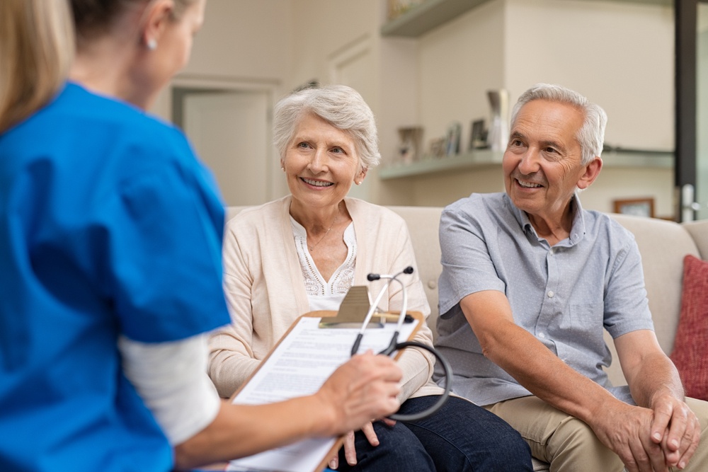 doctor explains to elder people at home about home care services