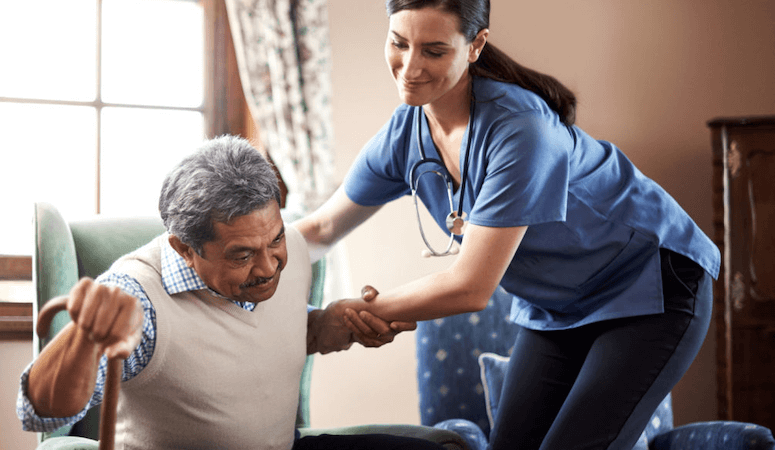 care taker helping aged person stand up